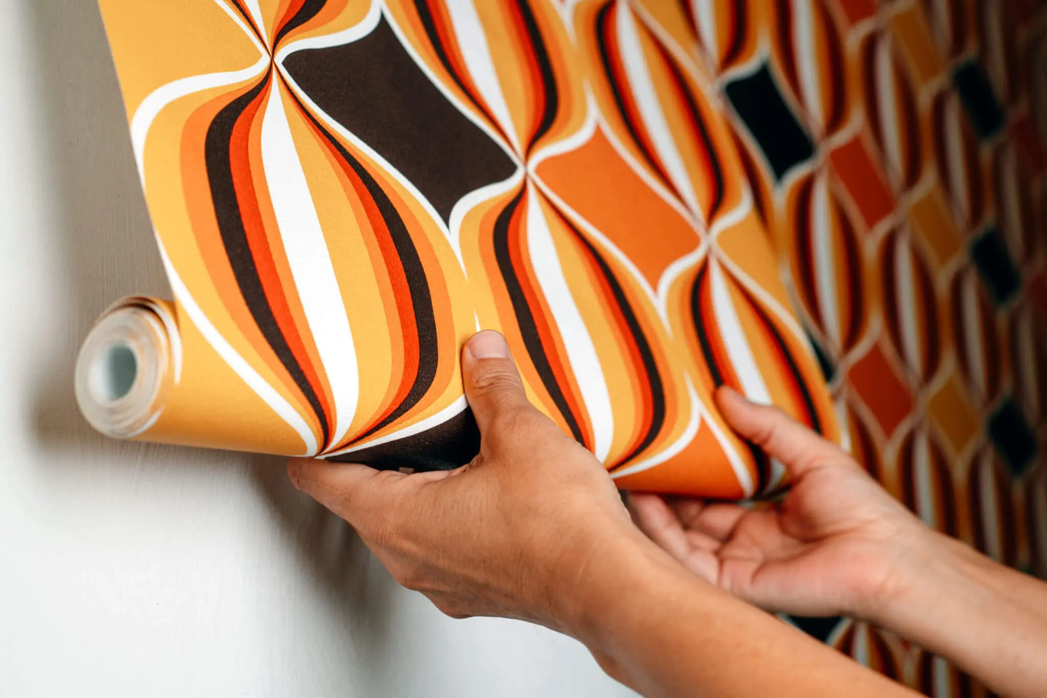 Applying retro patterned wallpaper by hand.