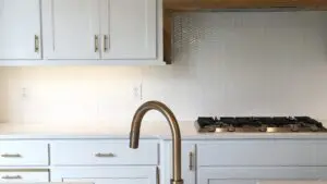 Modern kitchen with white cabinets and backsplash.
